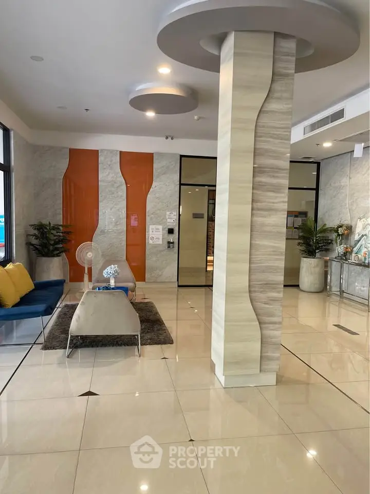 Modern lobby with stylish decor and seating area, featuring sleek design elements.