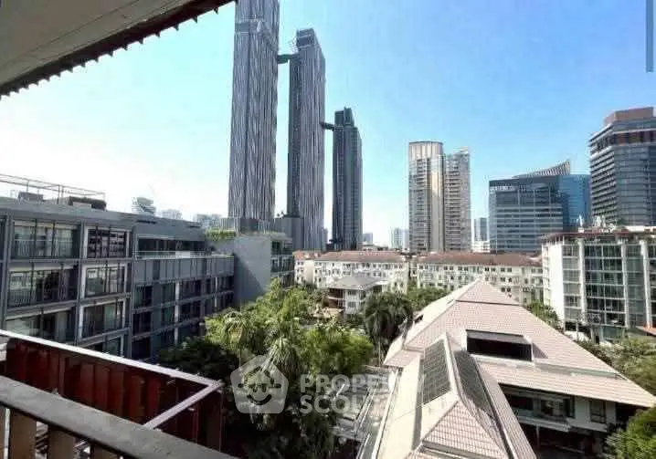 Stunning cityscape view from a high-rise balcony overlooking modern skyscrapers and lush greenery.