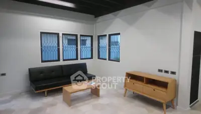 Modern living room with sleek black sofa and wooden furniture