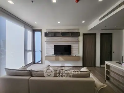 Modern living room with sleek design and large windows offering natural light.