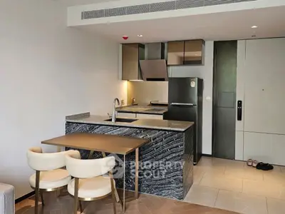 Modern kitchen with sleek black marble island and dining area in a stylish apartment.