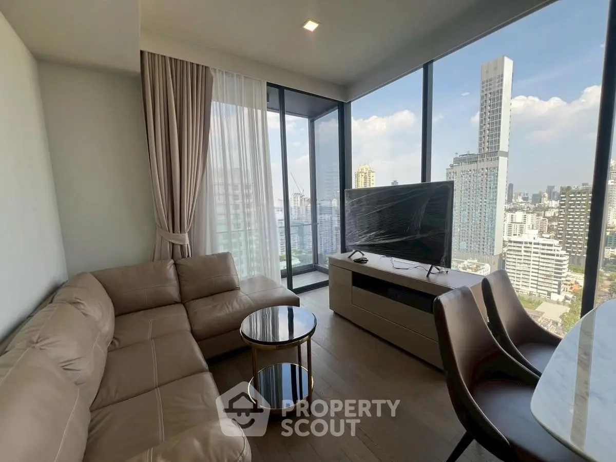 Modern living room with panoramic city view and stylish furniture in high-rise apartment.