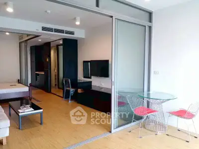 Modern open-plan living room with glass partition and stylish furniture