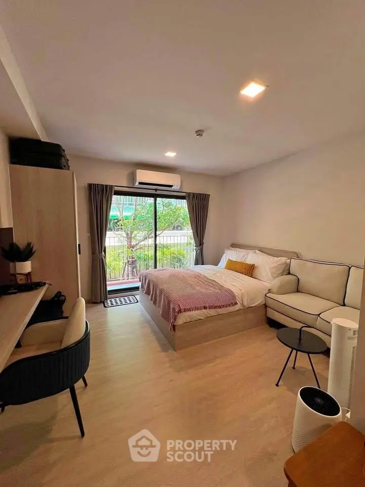 Modern studio apartment with cozy living area and balcony view
