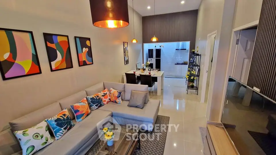 Modern living room with stylish decor and open layout leading to dining area and kitchen.