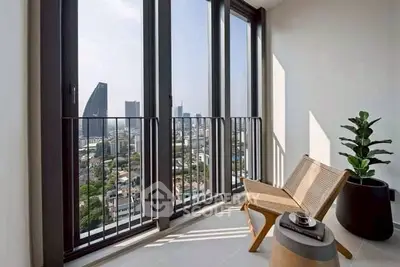 Stunning city view from modern balcony with stylish chair and plant, perfect for relaxation.