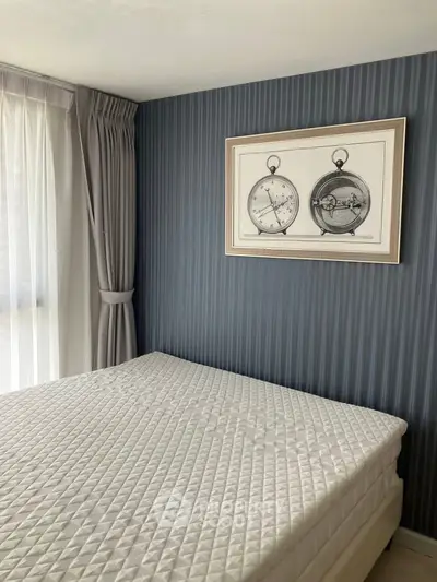 Cozy bedroom with elegant decor and large window for natural light.