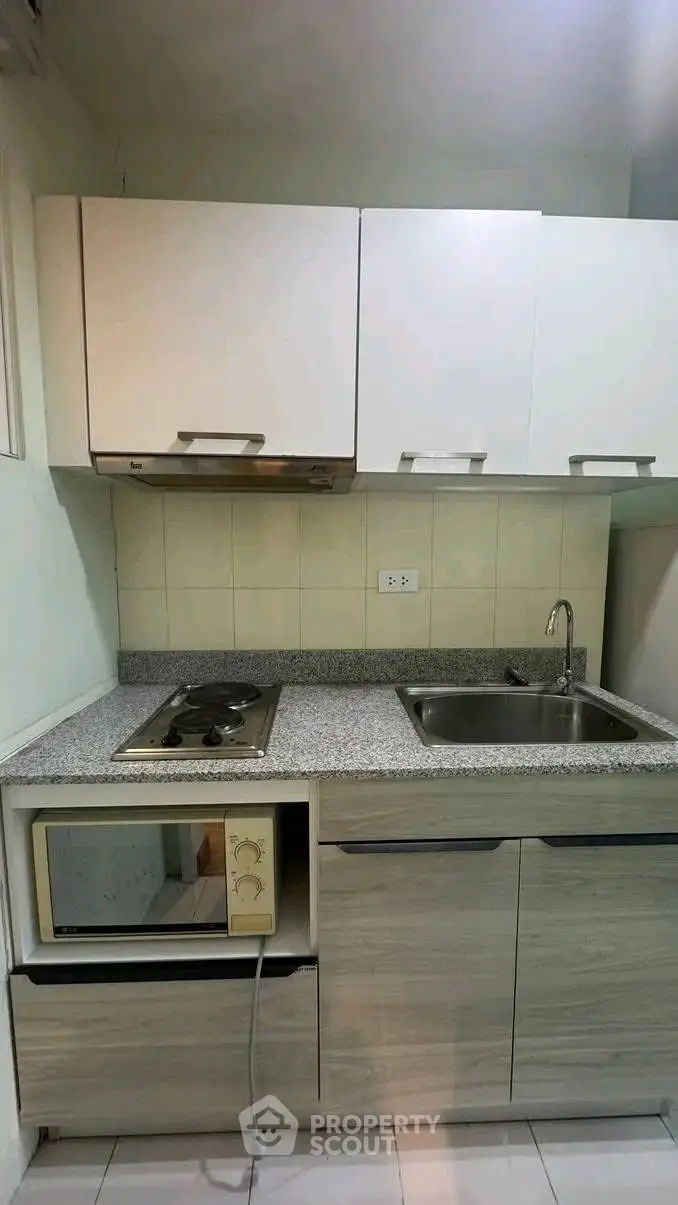 Compact kitchen with modern cabinetry and built-in appliances in a cozy apartment.