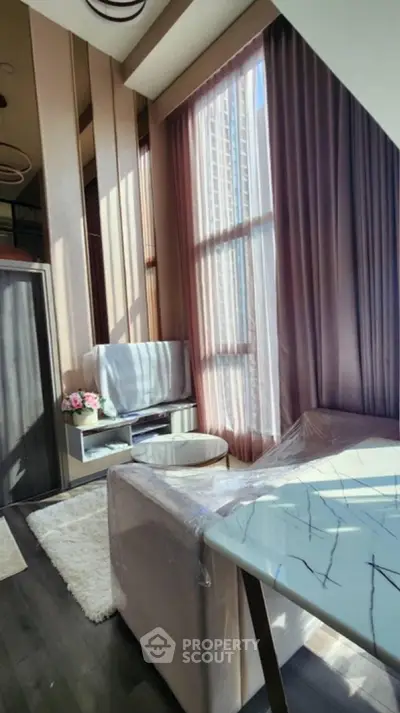 Luxurious high-ceiling living room with modern decor and large windows