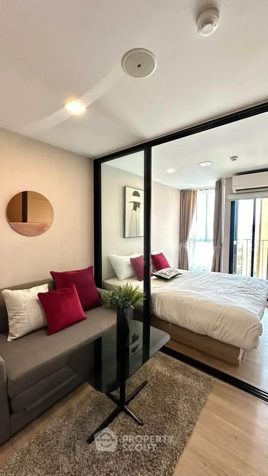 Modern studio apartment with glass partition, cozy living area, and stylish bedroom.