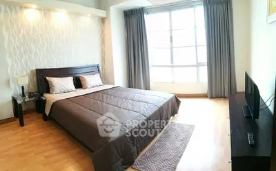 Spacious bedroom with large window and modern decor