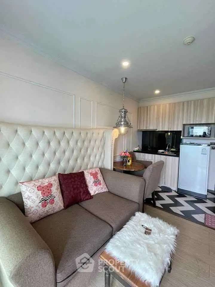 Chic living room with cozy sofa and modern kitchen in open layout apartment.