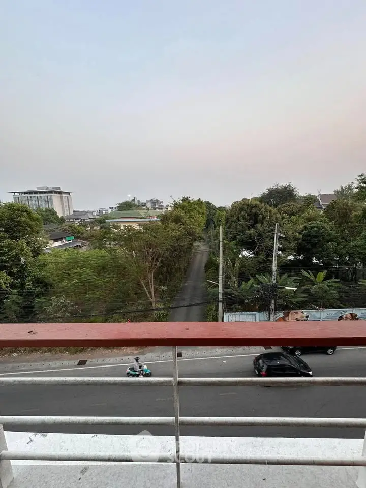 Scenic view from balcony overlooking lush greenery and urban landscape.