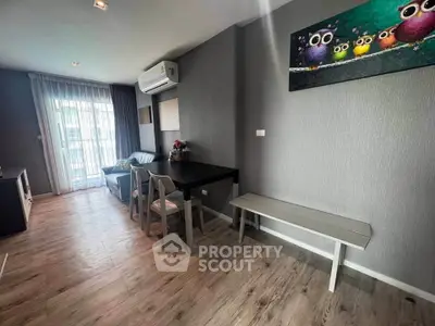 Modern living room with stylish decor and natural light, featuring a cozy seating area and contemporary artwork.