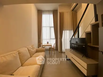 Modern living room with high ceilings and elegant decor in a stylish apartment.