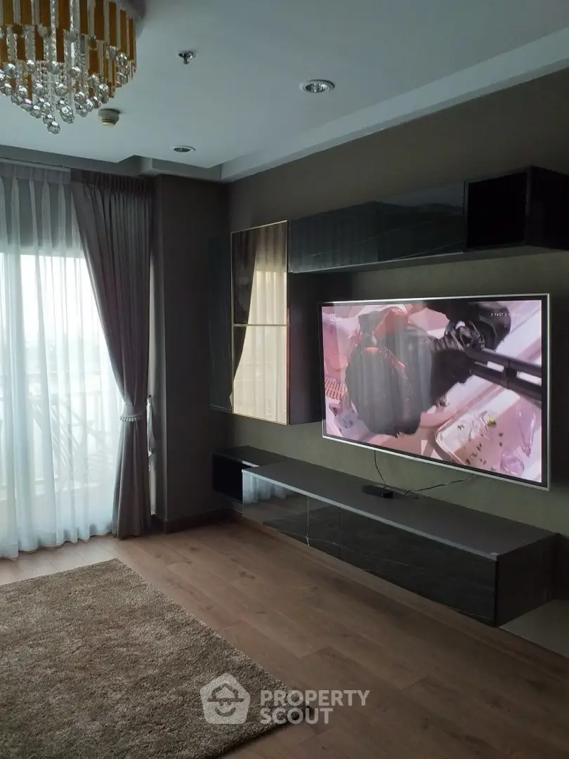 Modern living room with sleek TV setup and elegant chandelier