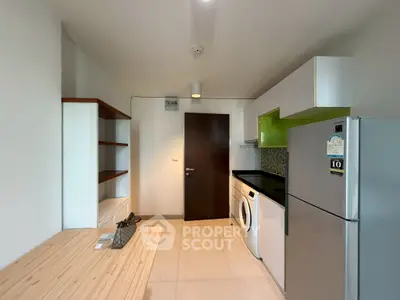 Modern kitchen with sleek appliances and ample storage in a contemporary apartment.