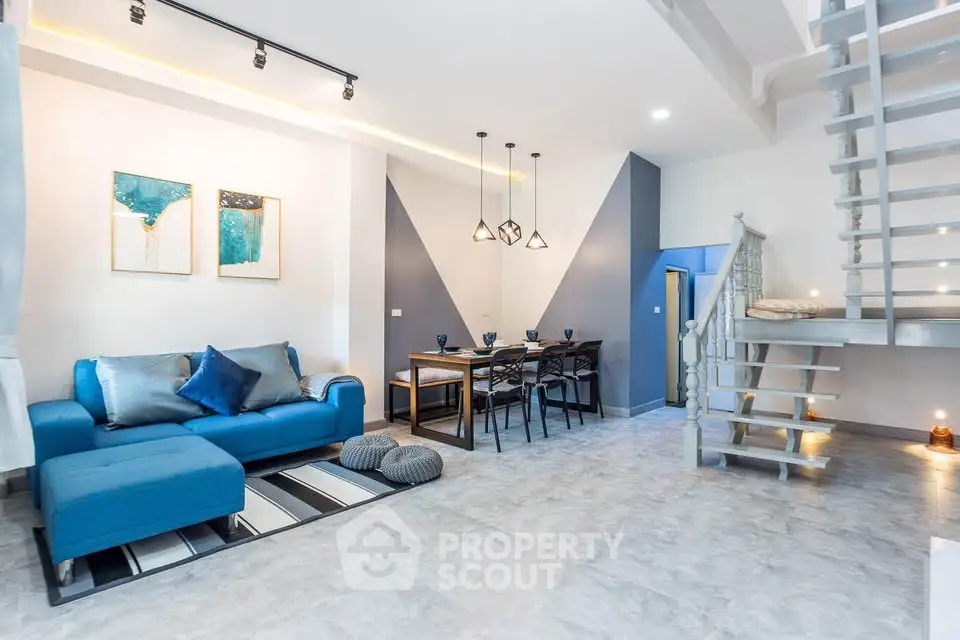 Modern living room with stylish decor and open staircase