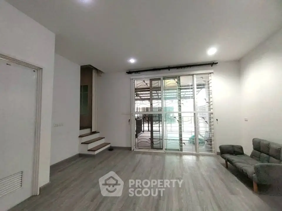 Spacious living room with modern flooring and large windows for natural light.