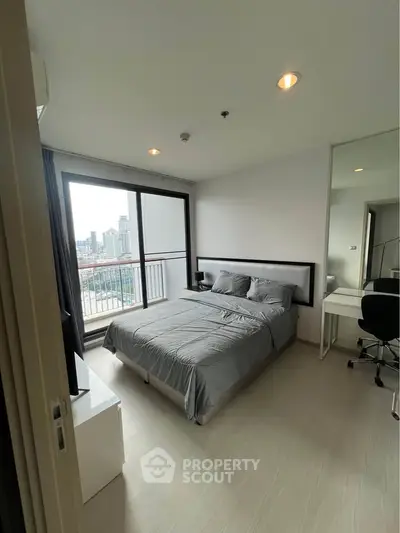 Modern bedroom with city view and balcony access in high-rise apartment