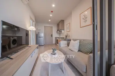 Modern living room with cozy sofa, stylish decor, and open kitchen layout in a contemporary apartment.