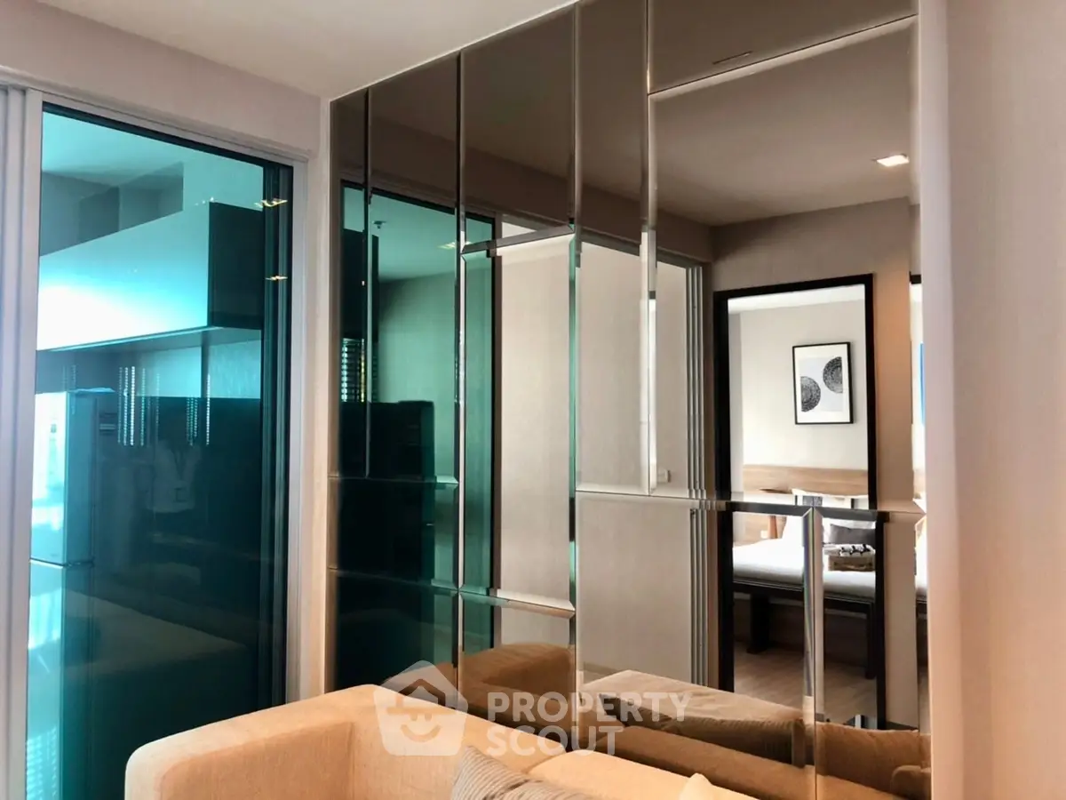 Modern living room with mirrored wall and cozy beige sofa in stylish apartment.