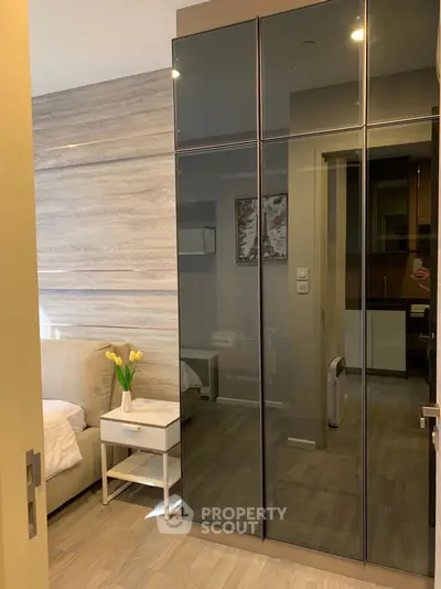 Modern bedroom with sleek mirrored wardrobe and stylish decor