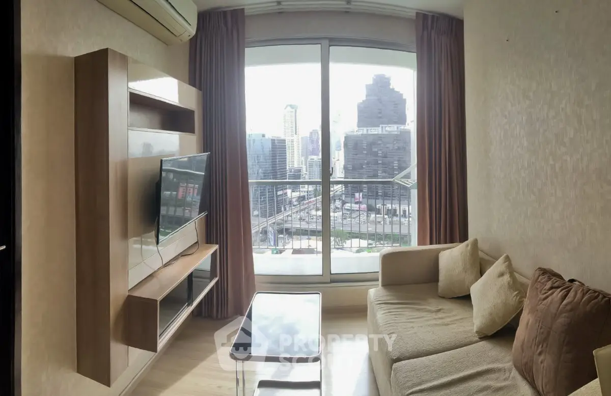 Modern living room with city view, featuring sleek furniture and large window for natural light.