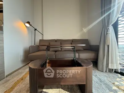 Modern living room with stylish sofa and multifunctional coffee table in a sunlit apartment.