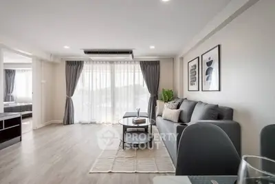 Spacious modern living room with elegant decor and large windows offering natural light.