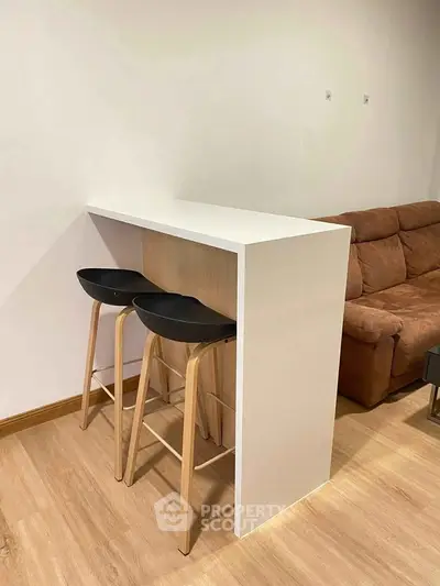 Modern living room with stylish bar stools and cozy sofa, perfect for entertaining guests.