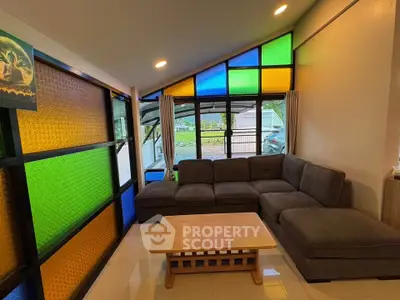 Vibrant living room with colorful stained glass windows and cozy sectional sofa
