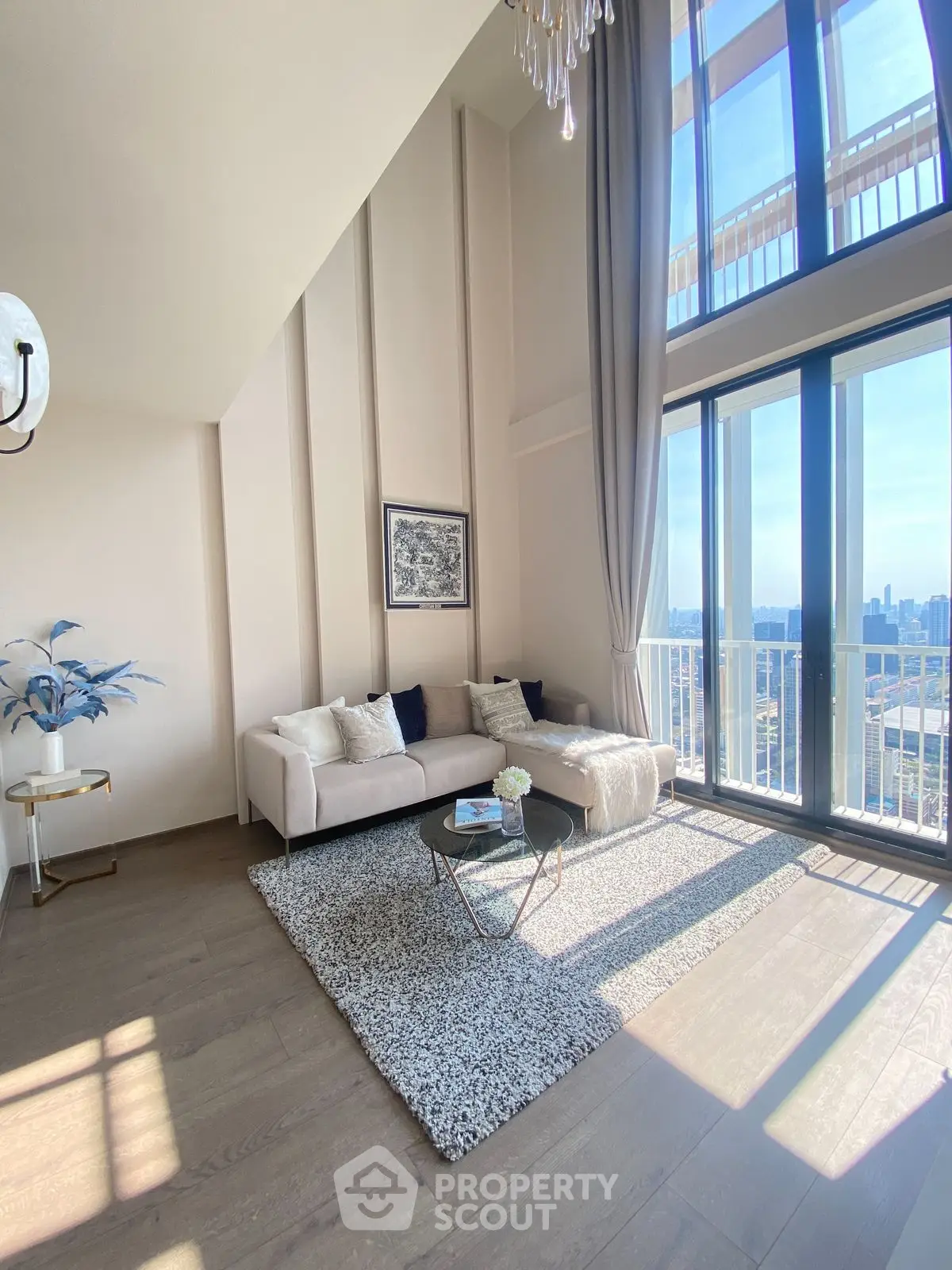 Luxurious high-ceiling living room with stunning city view and elegant decor.