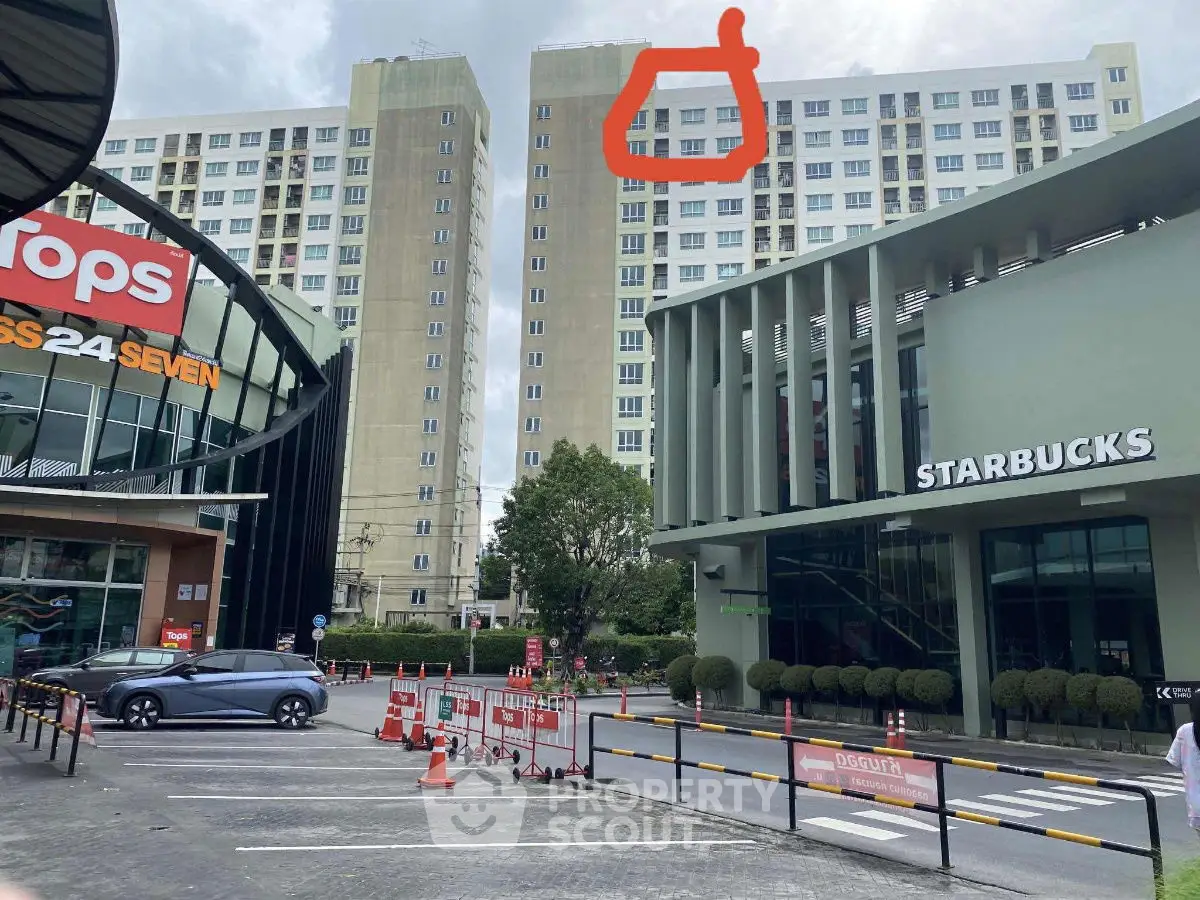 Modern commercial and residential complex with high-rise building and retail stores.