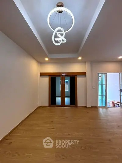 Spacious modern living room with elegant lighting and wooden flooring