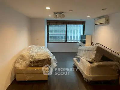 Spacious living room with modern furniture and large window view.