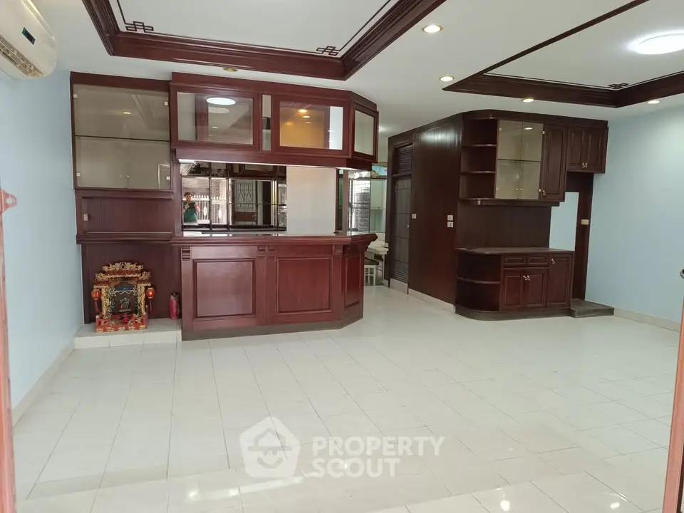 Spacious living room with elegant wooden cabinetry and ample natural light