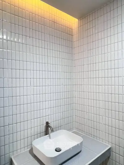 Modern minimalist bathroom with sleek white tiles and stylish sink