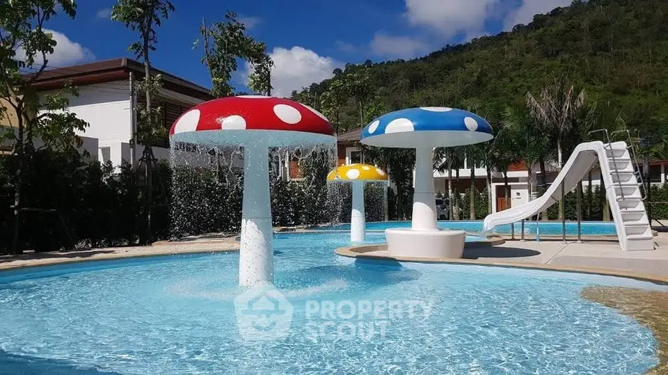 Stunning pool area with playful mushroom fountains and slide, perfect for family fun.
