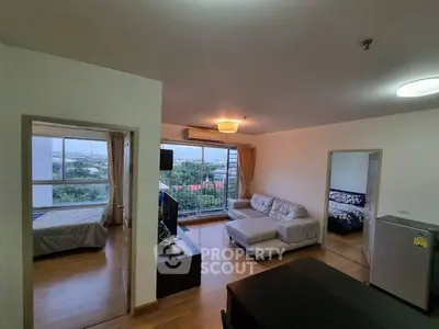 Spacious living room with large windows offering a stunning view, adjacent to a cozy bedroom.