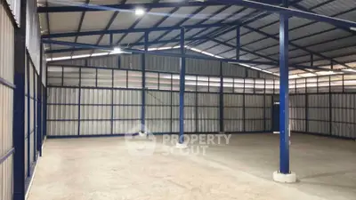 Spacious industrial warehouse with high ceilings and steel framework, ideal for storage or manufacturing.