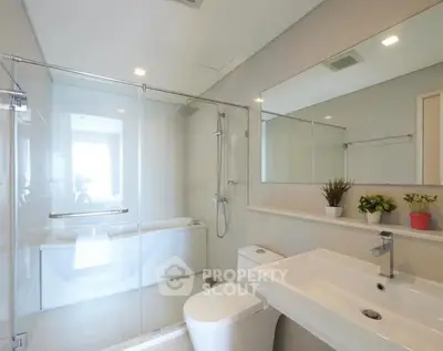 Modern bathroom with glass shower, bathtub, and sleek fixtures in a bright, minimalist design.