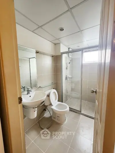 Modern bathroom with glass shower and sleek fixtures in a contemporary apartment.