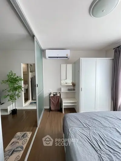 Modern bedroom with sleek design, featuring a large wardrobe, air conditioning, and stylish decor.