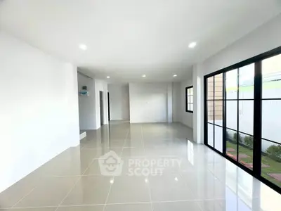 Spacious modern living room with large windows and glossy tiled floors