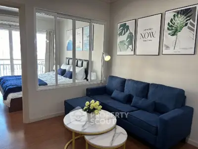 Modern living room with blue sofa and stylish decor adjacent to cozy bedroom