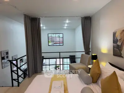 Modern loft bedroom with stylish decor and large window view