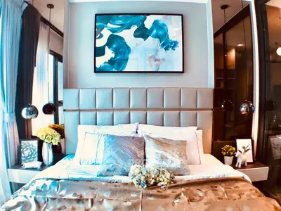 Luxurious bedroom with elegant decor, plush bedding, and modern art, offering a serene and stylish retreat.