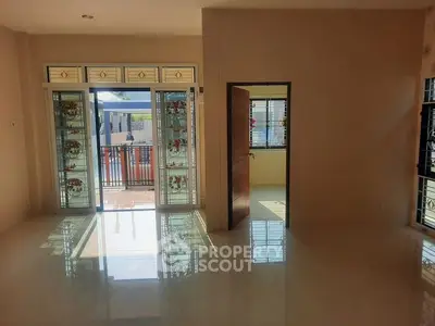Spacious living room with large windows and balcony access, perfect for natural light lovers.