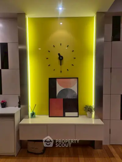 Modern living room with stylish wall clock and vibrant yellow accent wall